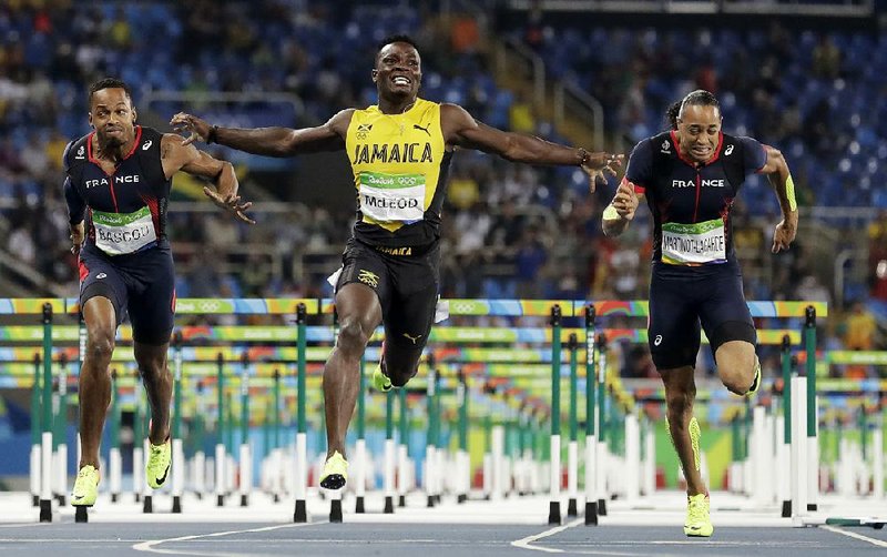 Former Arkansas Razorback Omar McLeod (center) of Jamaica wins the men’s Olympic 110-meter hurdles Tuesday night in Rio de Janeiro. McLeod became the first former male Razorback to win an individual gold medal in 24 years.