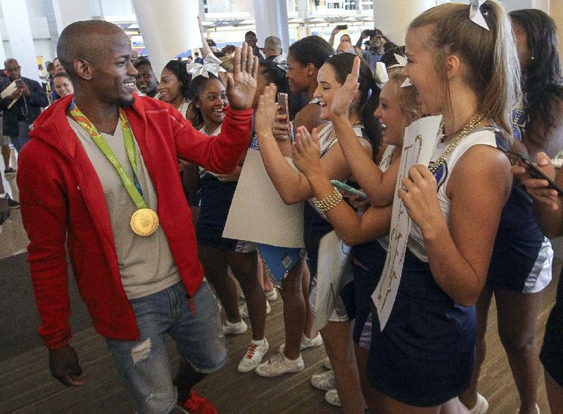 Jeff Henderson, who won the Olympic gold medal in the men’s long jump Saturday at Rio de Janeiro, is greeted by Sylvan Hills High School students at Bill and Hillary Clinton National Airport/Adams Field in Little Rock on Wednesday. Henderson graduated from Sylvan Hills in 2007.