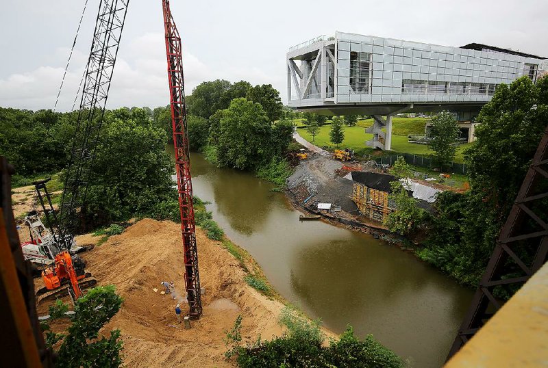 Work continues on a pedestrian bridge connecting the Arkansas River Trail beneath the Clinton Presidential Library onto a 9-acre island.