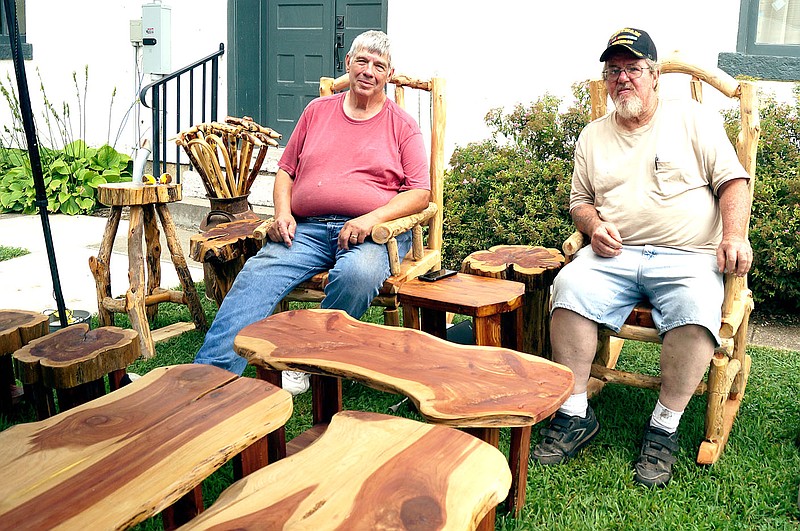 Rita Greene/McDonald County Press Left to right: Frank Jones of Monett and Mike Parvi known as Cedar Mike of Ridgely, showing their one-of-a-kind beautiful cedar furniture at Jesse James Days, Aug. 10-13 on the Square at Pineville.
