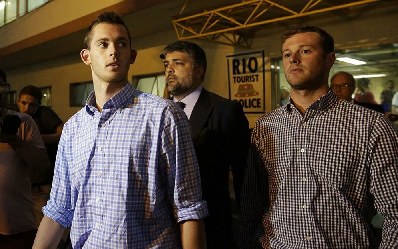 American Olympic swimmers Gunnar Bentz, left, and Jack Conger leave a a police station in Rio de Janeiro on Thursday. Bentz, Conger  and teammates Ryan Lochte and Jimmy Feigan are being investigated by Brazilian authorities for possibly lying about being robbed at gunpoint.