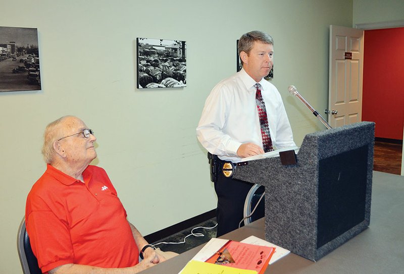 Conway Police Chief Jody Spradlin talks about scams as AARP President Ron Ross listens at an AARP meeting Monday at the Ola and John Hawks Senior Wellness and Activity Center in Conway.