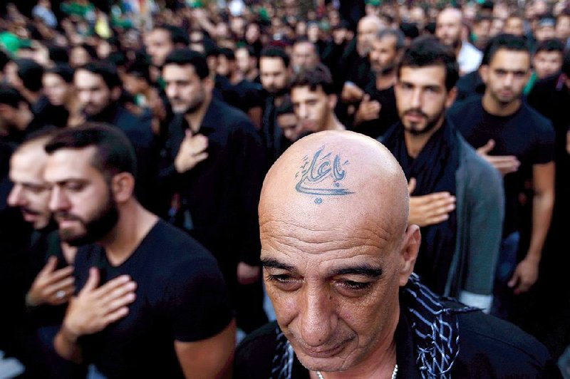 A Lebanese Shiite supporter of Hezbollah with a tattoo on his head that reads in Arabic, “Oh Ali,” is one of a growing number of Shiite Muslims in Lebanon getting tattoos with religious and other Shiite symbols. 