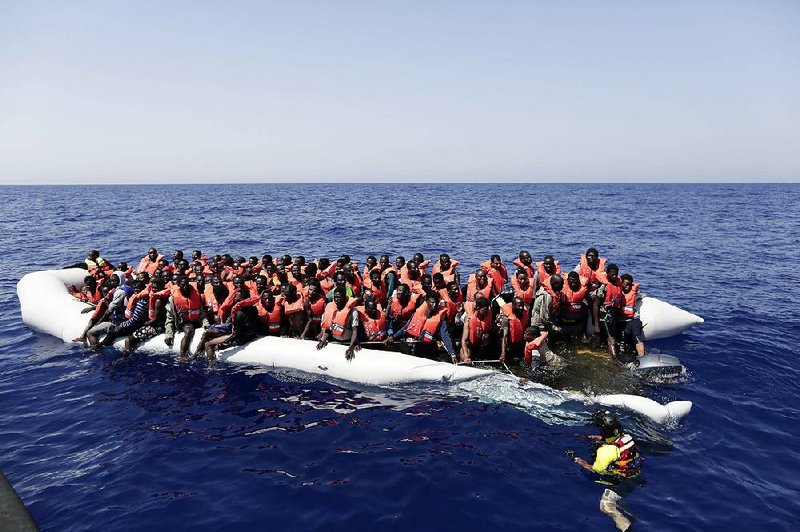 Migrants on a sinking dinghy in the Mediterranean Sea wait to be rescued Thursday. 