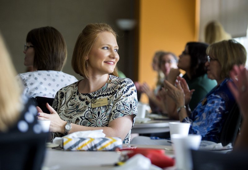 New employee Lindsey White, executive assistant to the president and board, listens Friday during a luncheon for new employees of the college at the Shewmaker Center for Global Business Development in Bentonville.