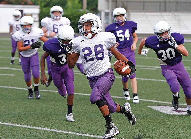 Terrance Armstard/News-Times Staff  Barton's Jamaza Cook (28) runs the ball while his teammates pursue during Barton's Purple and White game at Memorial Stadium Friday. This competition was among a series of games and activites that were presented. The nightcap was the Wildcat varsity holding its annual Purple and White scrimmage.