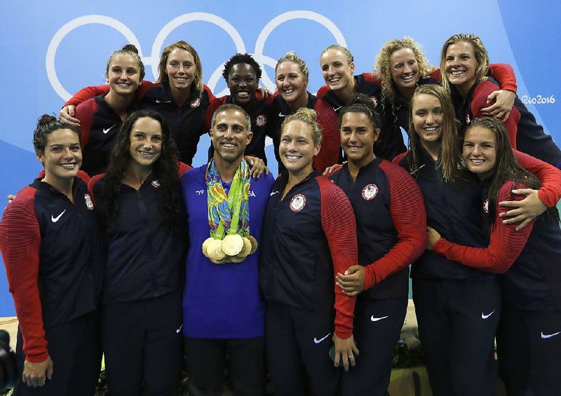 U.S. women’s water polo Coach Adam Krikorian (center) wears all 13 of his team’s gold medals after Friday’s
medal ceremony in Rio de Janeiro. Krikorian’s brother died two days before the Olympics started.