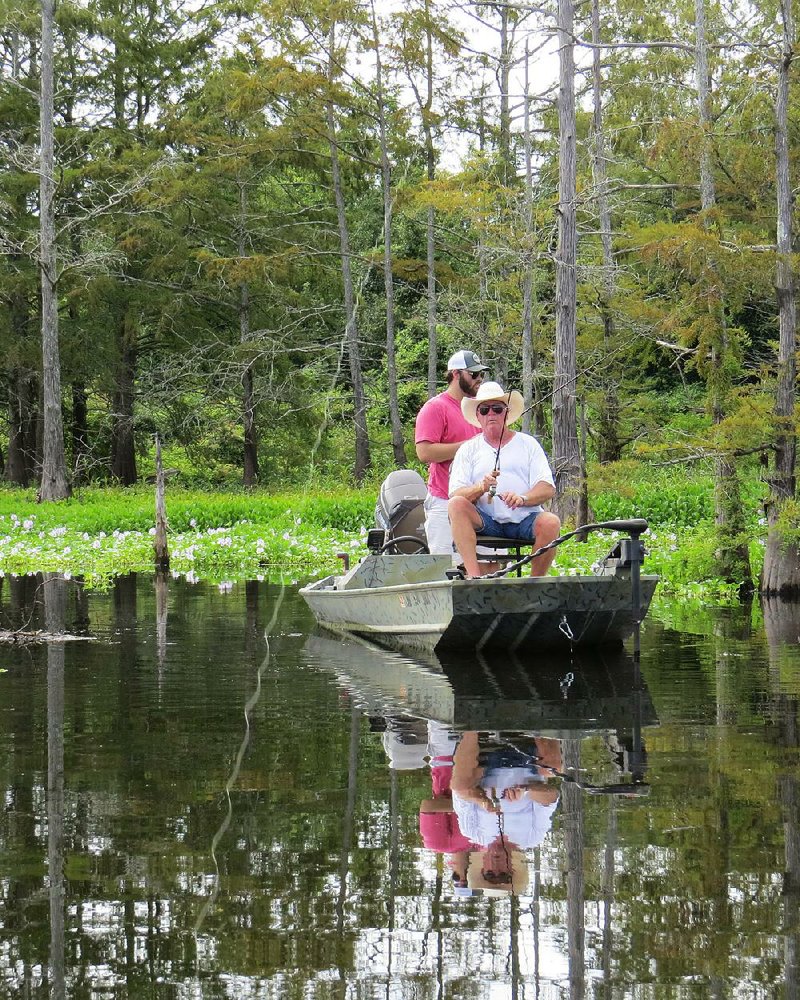 Willie Johnson and Hunter Field (rear) try to coax crappie from the hyacinth and coontail moss from Grampus Lake, northeast of Hamburg, on Friday.