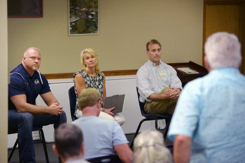 Eric White (from left), Beth Haney and incumbent Grant Lightle, candidates for the Bentonville School Board Zone 3 seat, listen to a question from Robert Anderson of Centerton Saturday during Coffee with the Mayor at Centerton City Hall.