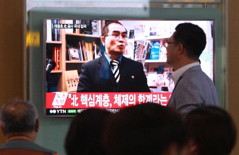 People watch a TV news program showing a file image of Thae Yong Ho, a minister at the North Korean Embassy in London, on Wednesday at Seoul Railway Station in Seoul, South Korea.