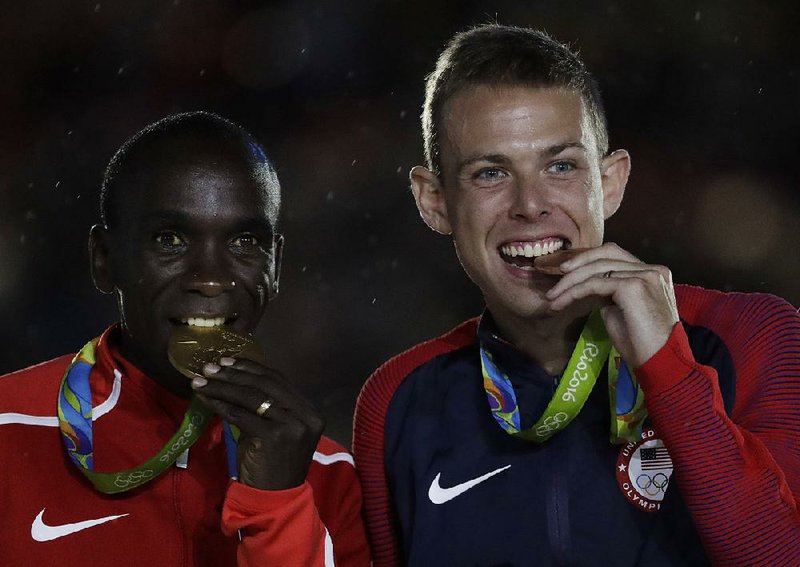 Kenyan gold medalist Eliud Kipchoge (left) and American Galen Rupp, who won the bronze, show off their medals during the medal ceremony following the men’s marathon at Maracana Stadium in Rio de Janeiro.