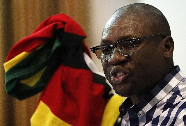 Zimbabwean pastor Evan Mawarire holds his country’s flag while singing the national anthem before addressing supporters at the University of the Witwatersrand in Johannesburg.