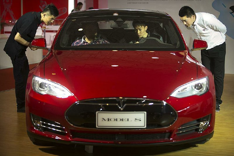Tesla’s Model S electric car, seen in April at the Beijing International Automotive Exhibition, is one of several cars with semi-autonomous driving features on the road today.