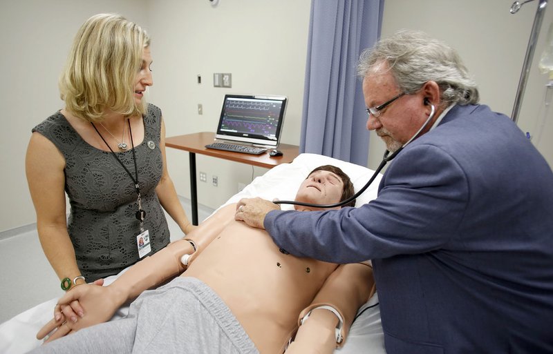 Dr. Natasha Bray (left), associate dean of Clinical Medicine at the Arkansas College of Osteopathic Medicine, demonstrates an adult simulator to Dr. Kenneth Heiles, dean of the Arkansas College of Osteopathic Medicine, Thursday in one of four simulator rooms at the college in Fort Smith. The Arkansas College of Osteopathic Medicine is in the process of interviewing students for the fall 2017 opening.