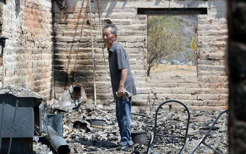 Yo Chu Pak stands Monday in what was the living room of his burned home off California 138, near Wrightwood, Calif., for the first time since the Blue Cut Fire swept through the area.