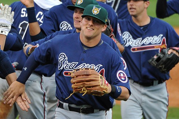 Lynchburg minor league Future Stars' Josh Elander, center, who hit a seventh-inning inning grand slam, congratulates teammates after their exhibition baseball game against the Atlanta Braves Saturday, March 29, 2014, in Rome, Ga. The Future Stars won 13-4. (AP Photo/David Tulis)