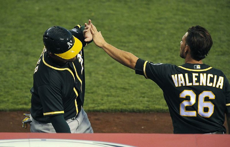 Oakland Athletics teammates Danny Valencia (right) and Billy Butler were high-fiving on Aug. 4, but they came to blows in a clubhouse scuffle Friday. 