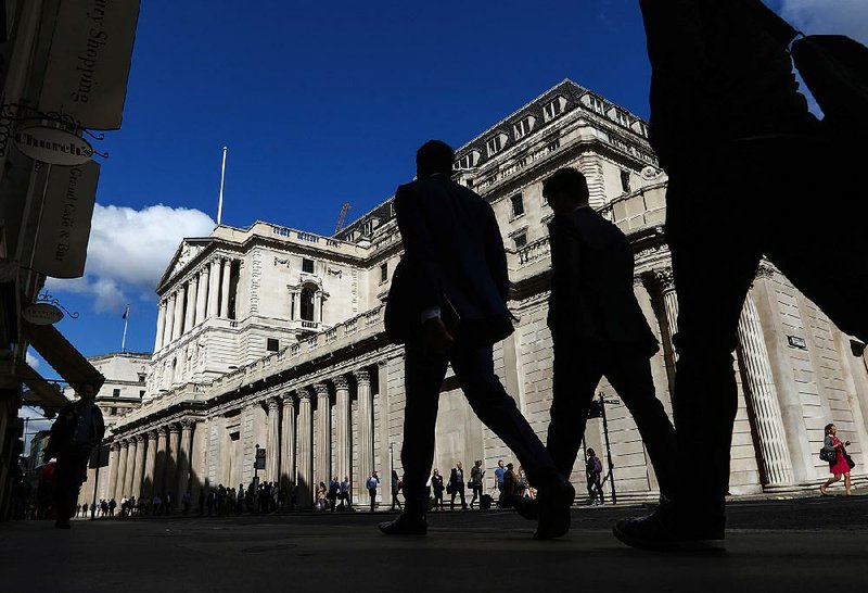 Pedestrians pass the Bank of England in London, in this July file photo. A German lawmaker Tuesday said transactions between London’s financial center and European Union nations won’t continue as normal after the U.K. exits the bloc. 