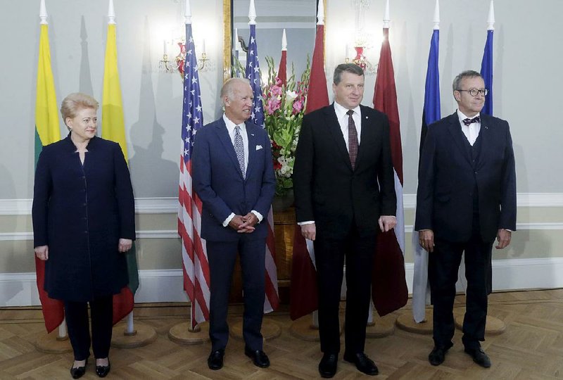 Lithuanian President Dalia Grybauskaite (from left), U.S. Vice President Joe Biden, Latvian President Raimonds Vejonis and Estonian President Toomas Hendrik Ilves pose for a photo during a news conference after their meeting in Riga, Latvia, on Tuesday. Biden has reaffirmed America’s commitment to defending the Baltic nations of Latvia, Lithuania and Estonia against any threat from neighboring Russia.