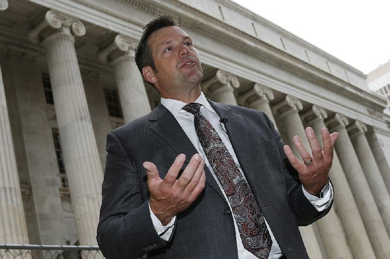 Kansas Secretary of State Kris Kobach responds to questions Tuesday outside the 10th U.S. Circuit Court of Appeals in Denver after delivering an argument in the legal fight over how the state of Kansas enforces its proof-of-citizenship requirement for voters who register at motor vehicle offices.