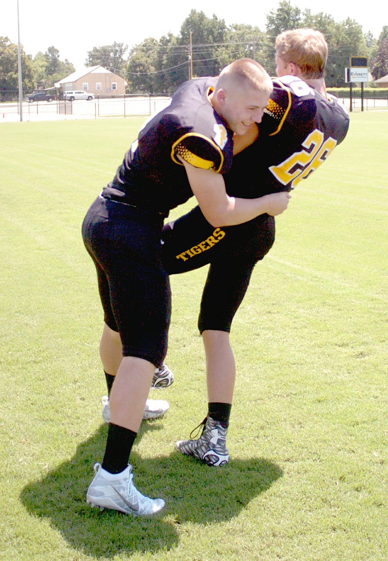 MARK HUMPHREY ENTERPRISE-LEADER Prairie Grove senior Zeke Laird, shown playfully wrapping up teammate Clay Fidler, was second in tackles among Tiger defenders in 2015.