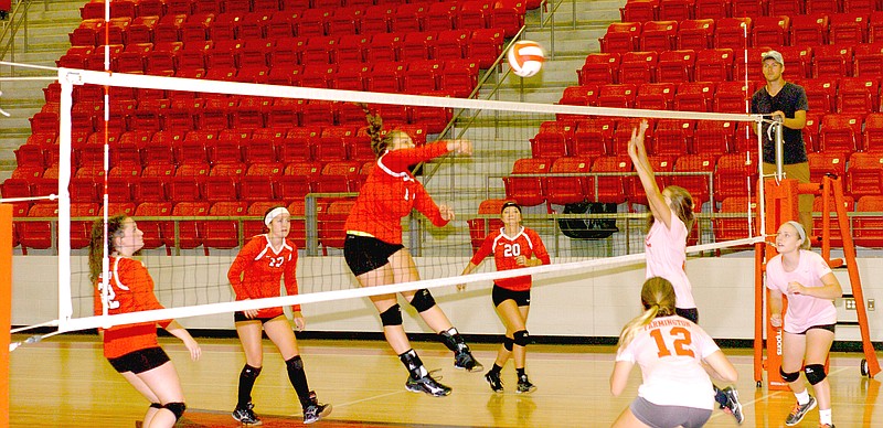 Photos by Mark Humphrey Enterprise-Leader Top: Claudia Oxford smashes a hit against Prairie Grove. The rivals met at Cardinal Arena in a pre-season benefit volleyball match won by Farmington Aug. 15. Above: Anna Dutton pounds a hit for the Farmington volleyball team against a group of Lady Cardinal alumni Friday.