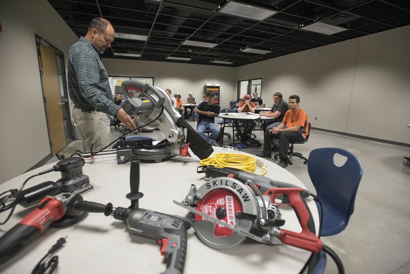 Chris Weeks, construction professions teacher at West High School, shows students a variety of power tools Tuesday in Centerton. The tools were donated by Burckart Construction and Garner Building Supply.