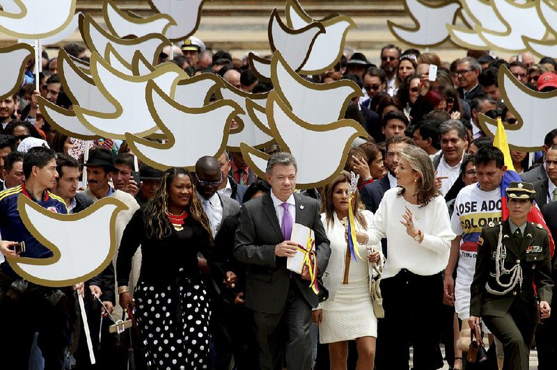 President Juan Manuel Santos walks to the Congress building Thursday in Bogota carrying the text of the peace deal with the Revolutionary Armed Forces of Colombia.