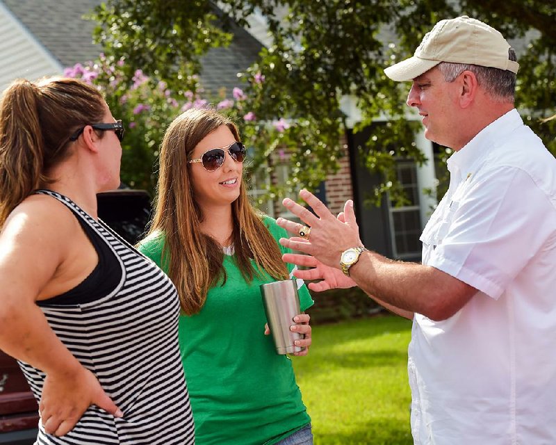 Louisiana Gov. John Bel Edwards talks with Jessica Venable (left) and Nicole Sylvester during his tour of damaged neighborhoods Thursday. 
