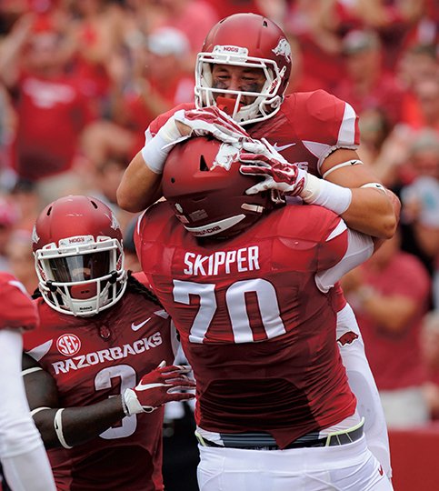 NWA Democrat-Gazette/Andy Shupe HEFTY HEAVE: Dan Skipper (70) lifts wide receiver Drew Morgan after an Arkansas touchdown against UTEP last year. Skipper, an offensive tackle, is the only Razorback named to the coaches' preseason all-Southeastern Conference team announced Thursday.