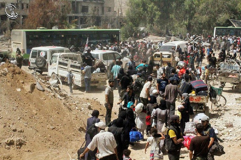 Syrians begin to move out of Daraya, where buses, ambulances and U.N. vehicles were waiting for the green light to pick them up Friday. 