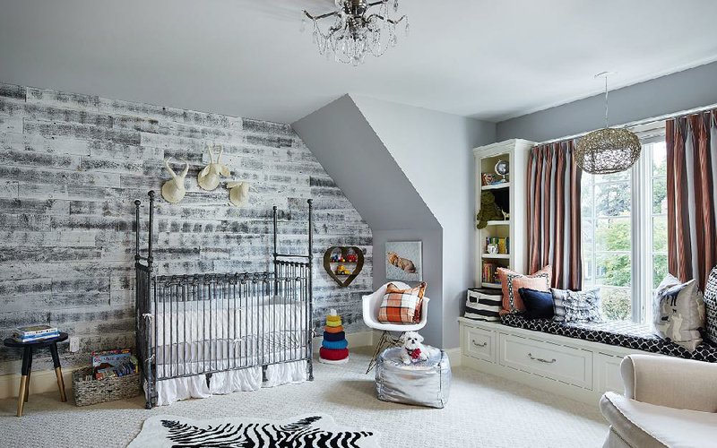 This undated photo provided by Stikwood shows a baby room with a wood wall designed by Carrie Rodman. Wood walls are a strong decor trend, and they’re a far cry from the dowdy paneling of decades past. Reclaimed wood is sawed into thin planks that can be attached to walls using adhesive or adhesion strips ready for mounting directly out of the box.