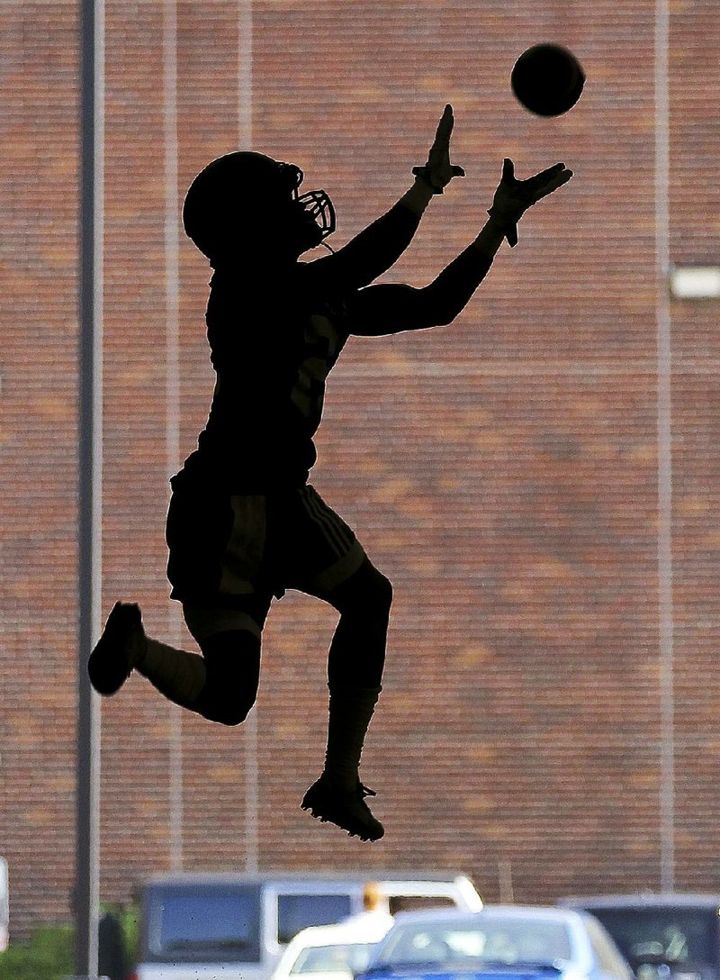 A Central Arkansas player leaps to make a catch during preseason workouts in Conway. With a coaching staff that includes five new assistant coaches, the Bears open the season Thursday at home against Houston Baptist. 