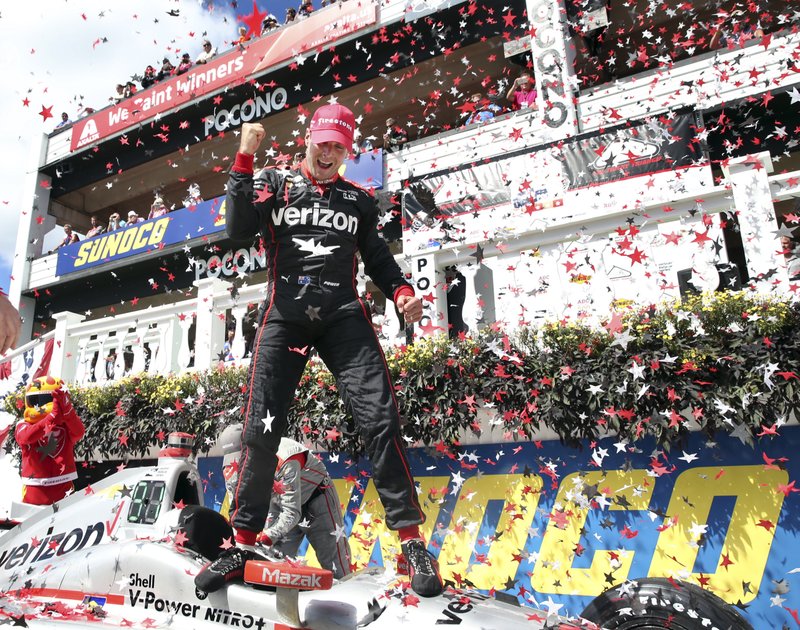 Will Power, of Australia, pumps his fist as he stands on his car and celebrates in Victory Lane after winning the Pocono IndyCar 500 auto race Monday, Aug. 22, 2016, in Long Pond, Pa. Mikhail Aleshin, of Russia, (7) was second. 