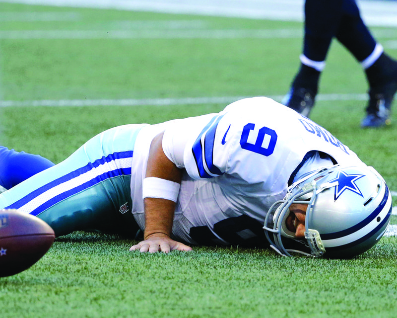 Dallas Cowboys quarterback Tony Romo lies on the turf after he went down on a play against the Seattle Seahawks during the first half of a preseason game, Thursday evening in Seattle.