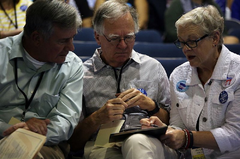 Joe Hudson (from left), Rob McCorkindale and Sherry Bishop, all of Harrison and representing Boone County, discuss strategy Saturday during the Democratic Party of Arkansas’ state convention at Shorter College in North Little Rock.