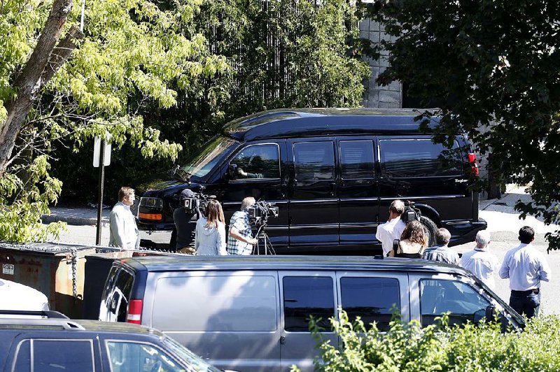 Reporters watch Saturday as Hillary Clinton’s van leaves an FBI facility in White Plains, N.Y., after she received her first intelligence briefing since becoming the Democratic presidential nominee.