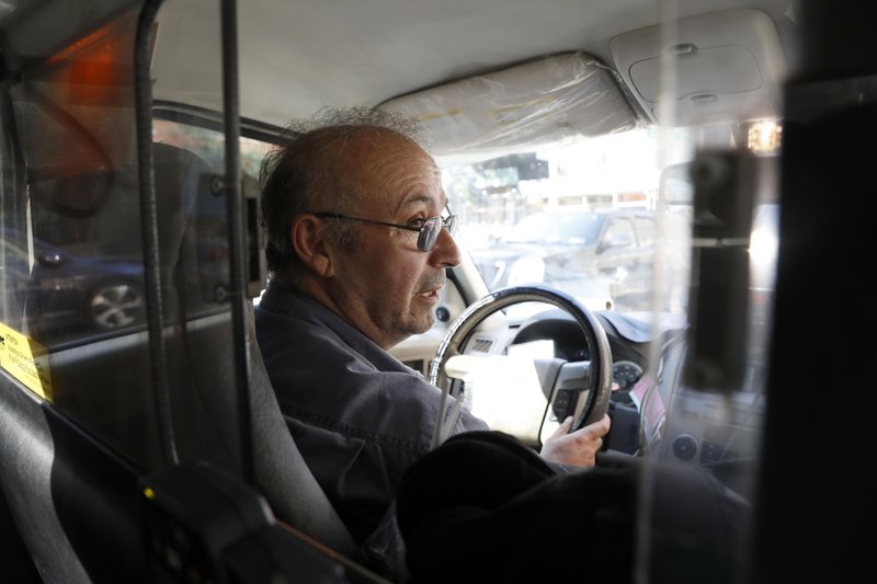 In this Wednesday, Aug. 24, 2016 photo, taxi driver Mikhail Yasayev speaks to an Associated Press reporter while stopped in traffic on the West Side highway in New York. 