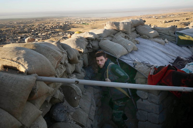 In this Thursday, Nov. 12, 2015 file photo, a Kurdish peshmerga fighter pauses during an operation to retake the northern Iraqi town of Sinjar. 