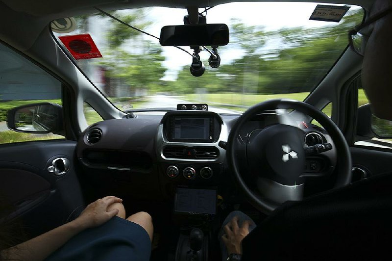 A driver (right) gets his hands off of the steering wheel of an autonomous vehicle during its test drive in Singapore last week.