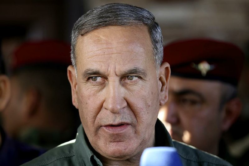 In this Wednesday, March 9, 2016 file photo, Iraqi Defense Minister Khaled al-Obeidi, center, speaks to reporters at a military a base outside Tikrit, 130 kilometers (80 miles) north of Baghdad, Iraq. 