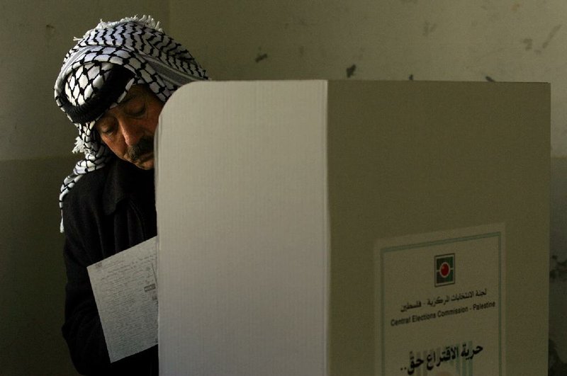 A Palestinian police officer fills in his ballot before casting it in parliamentary elections in the West Bank city of Nablus in this Jan. 22, 2006, file photo.