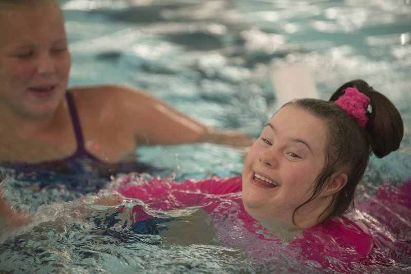 NWA Democrat-Gazette/J.T. WAMPLER Cassidy Bartels of Bella Vista, (right) and Izzy Gifford, both 12, swim Wednesday at the Walton Life Fitness Center in Bentonville. Bartels is training for the fifth annual Trifest for MS in Bentonville, a triathlon put on by the Rampy MS Research Foundation. The Bentonville School District is sponsoring the Trifest entries of 50 students with special needs, as well as a six-week training course for them.