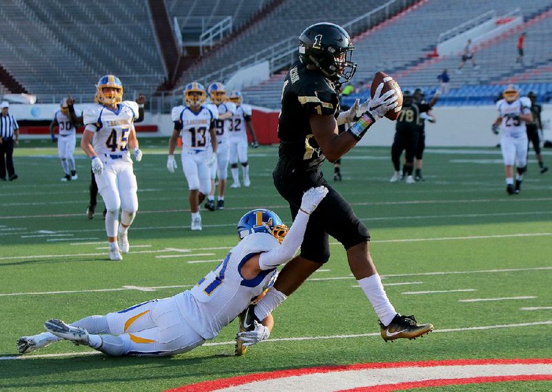 Robinson wide receiver Koilan Jackson (1) drags Hot Springs Lakeside defensive back Brandon Chambers across the goal line to score one of the Senators’ seven first-half touchdowns during Monday night’s game at War Memorial Stadium in Little Rock. Robinson jumped out to a 24-0 lead and never looked back.