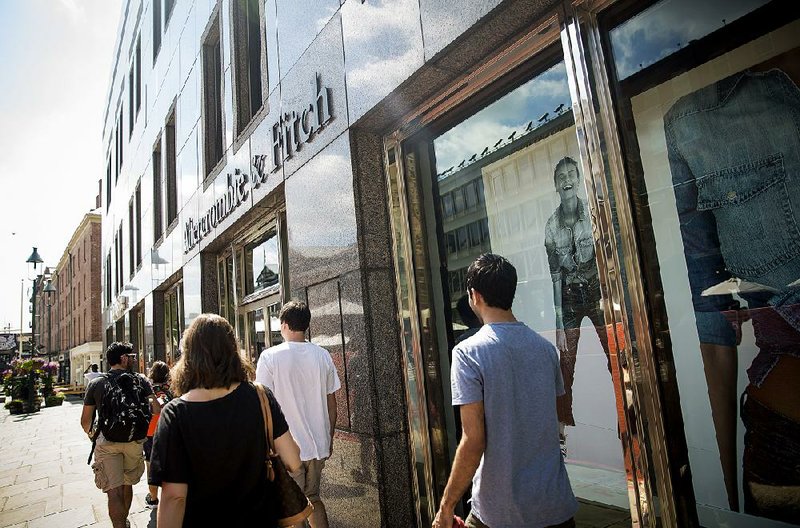 Pedestrians pass an Abercrombie & Fitch Co. store on Friday in New York. Spending by American consumers grew 0.3 percent in July, the Commerce Department said Monday.
