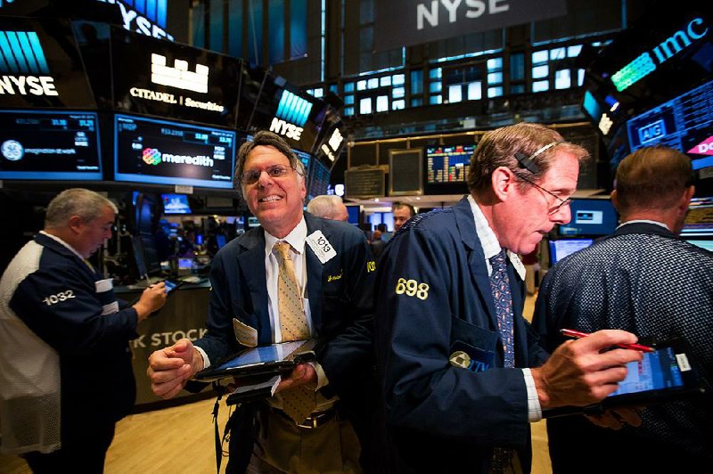 Traders work Monday on the floor of the New York Stock Exchange.