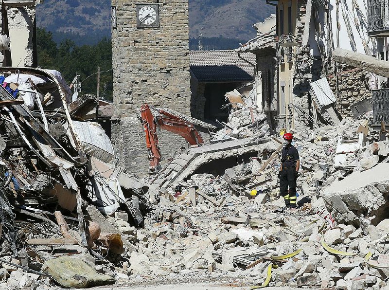 A firefighter in Amatrice, Italy, on Monday works to clear the rubble of buildings destroyed in an earthquake last week.