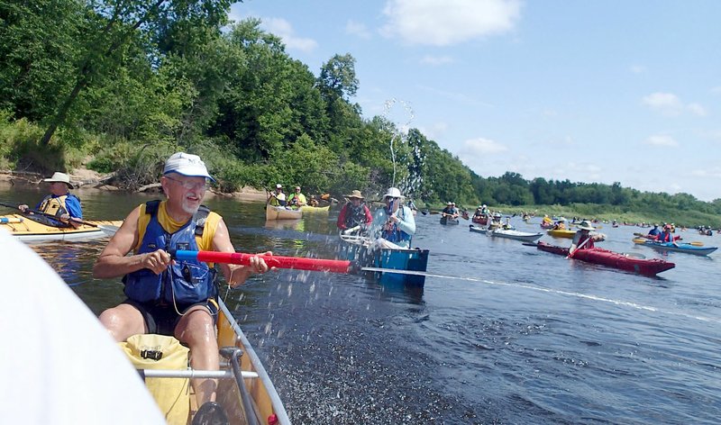 Paddlers on the Great River Rumble headed down the Chippewa River in Wisconsin Aug. 2 keep cool with a spirited water gun battle. The 21st annual trip covered 100 miles on the Chippewa and Mississippi rivers.