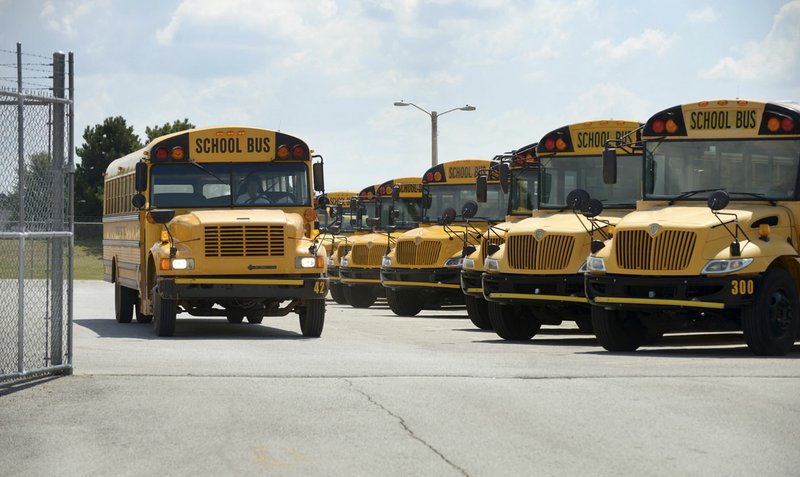 School buses pull out to begin their afternoon routes Monday at the Bentonville School District’s transportation department.