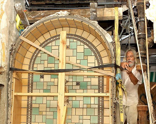 The Sentinel-Record/Richard Rasmussen DELICATE WORK: Kimbo Dryden of Dryden Properties Inc. secures the recessed tile fountain located in the lobby of the Majestic Hotel's "red brick" building Monday. It's one of several features the city hopes to salvage before the condemned complex of buildings is demolished.